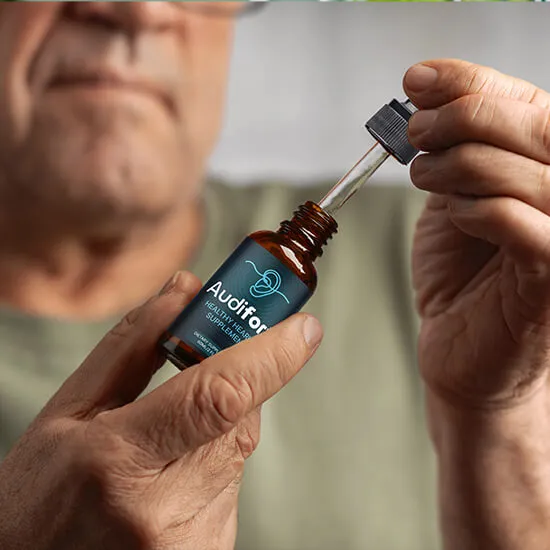 Man holding an Audifort bottle in one hand and its glass dropper in the other